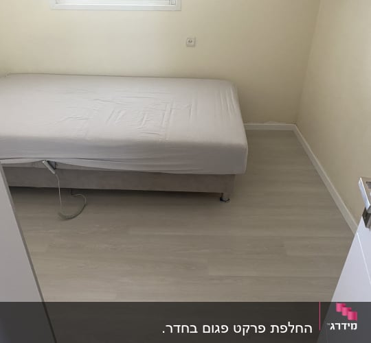 רצפת פרקט בהירה בחדר שינה עם מיטה
